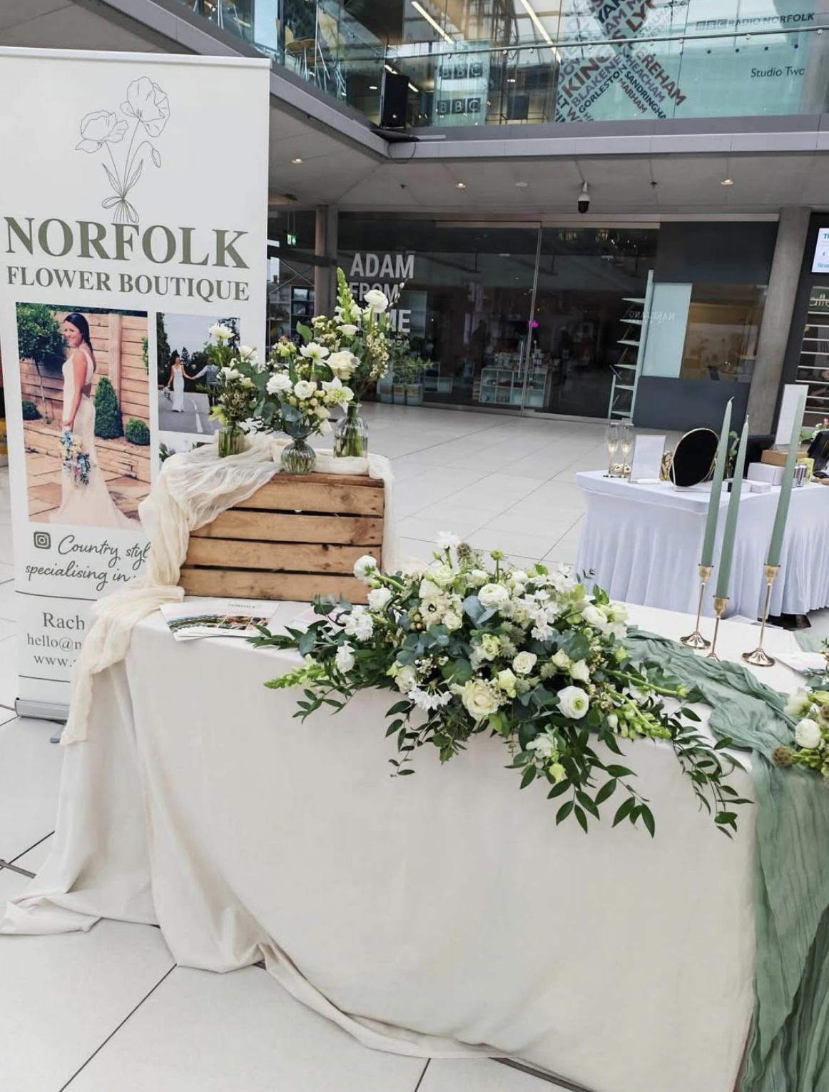 Norfolk Flower Boutique wedding fair stand with a white and green top table arrangement and branded banner