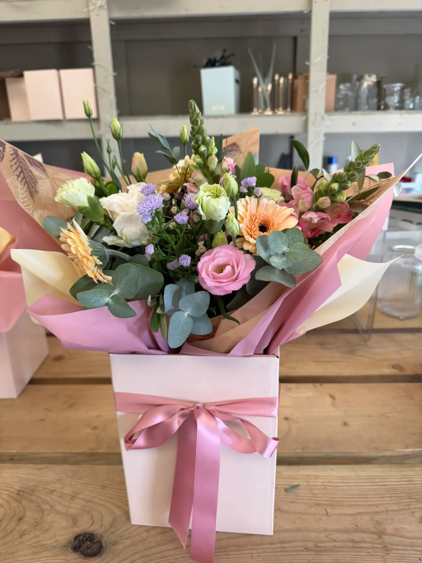 Celebration bouquet in a pink gift box tied with a satin bow