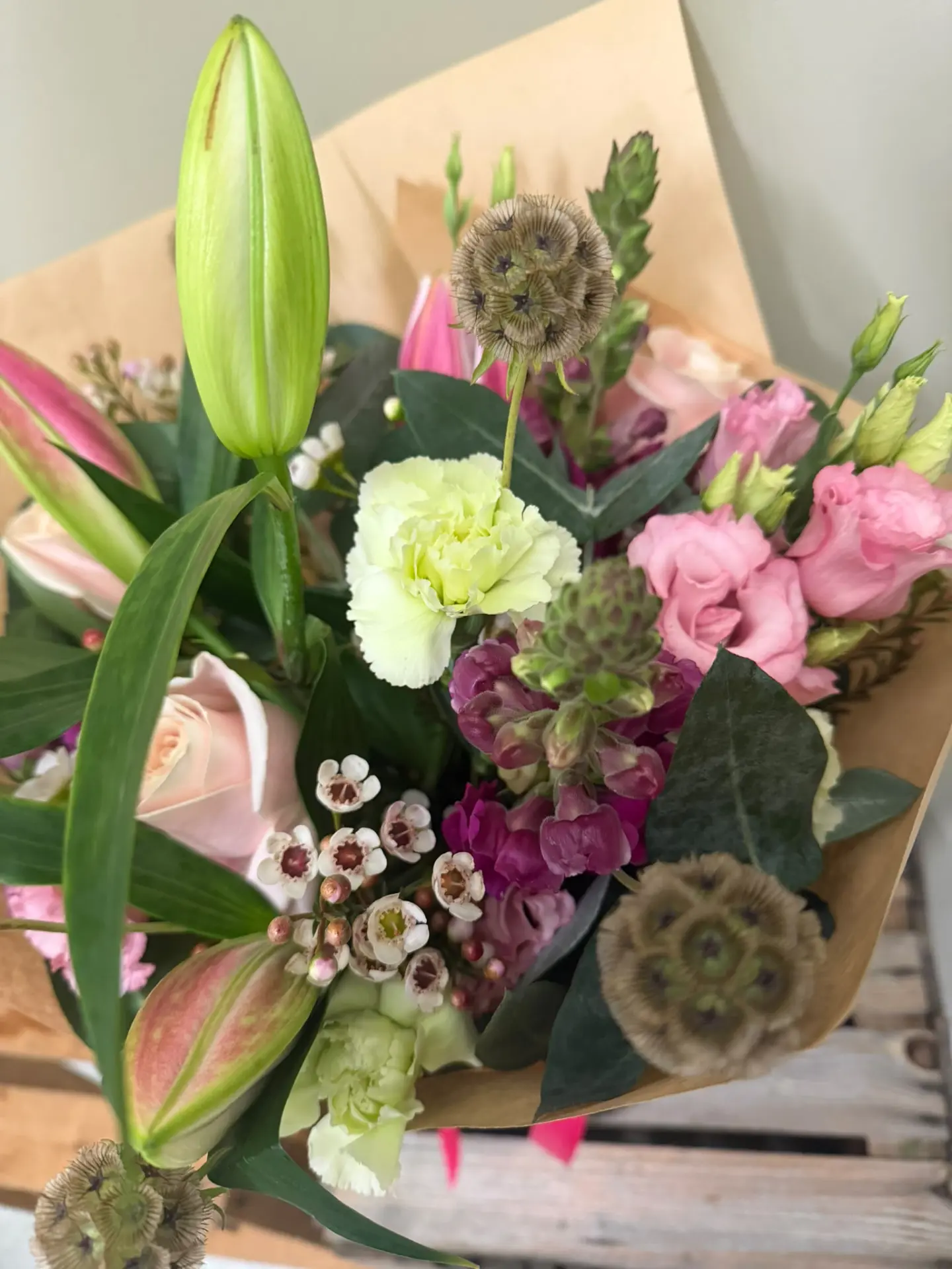 Country-style mixed bouquet with lilies, carnations and scabious seed heads