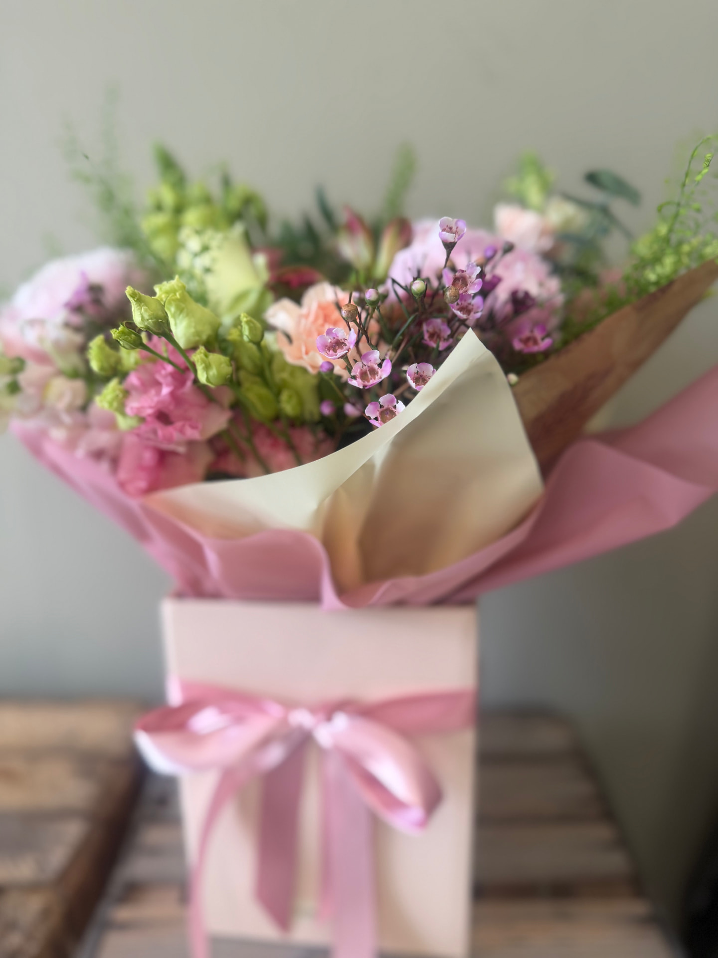 Fresh flowers presented in a pink gift box with ribbon